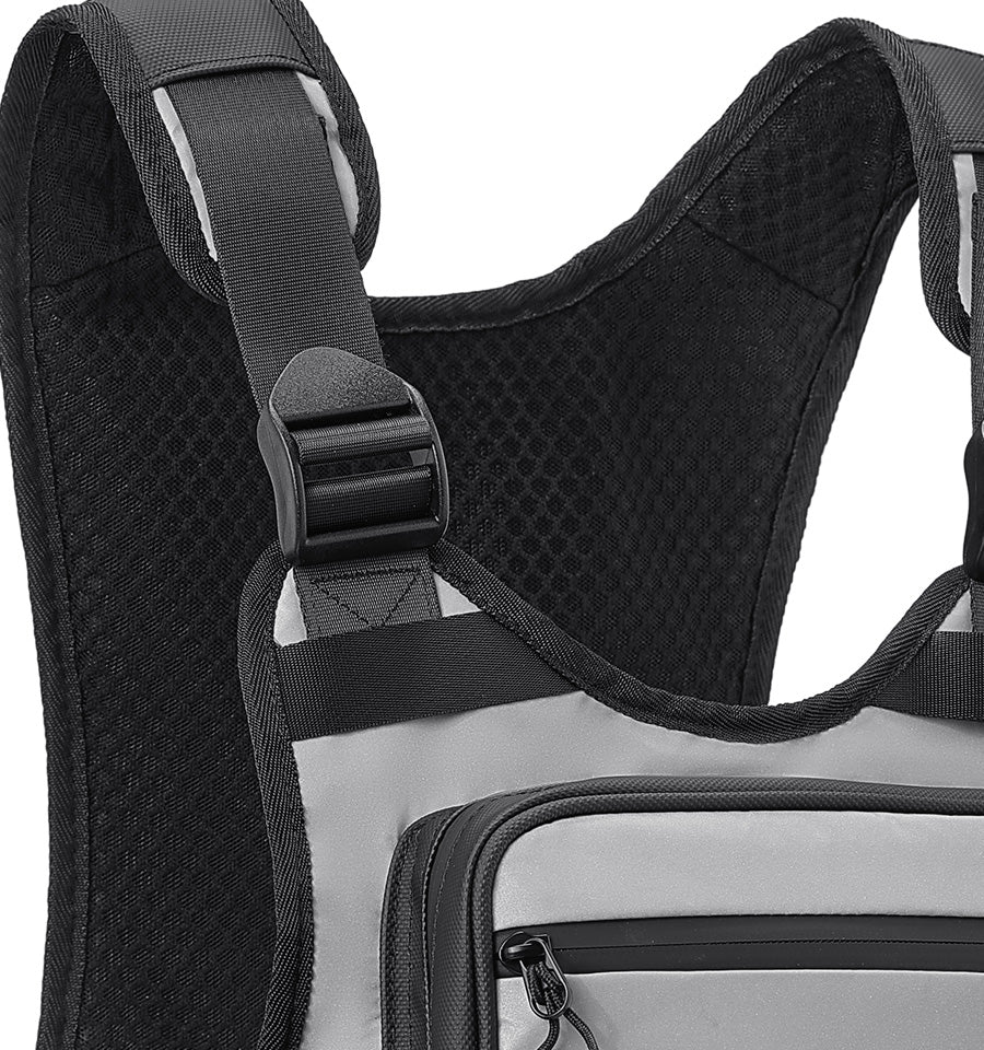 Close-up of a black and light gray backpack showing the padded shoulder strap, mesh back panel, and front zippered pocket.