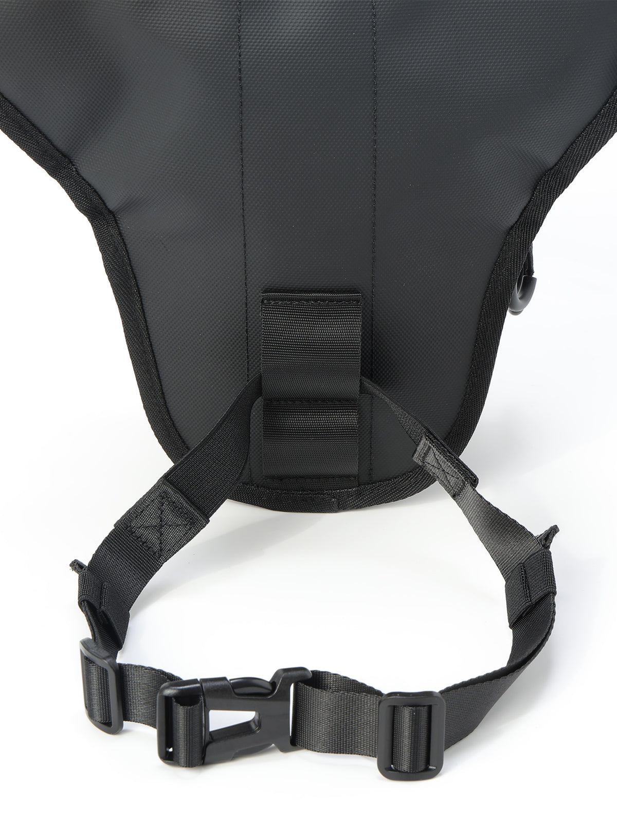 Close-up of the back of a black backpack showing the padded back panel, strap attachment point, and adjustable webbing strap with plastic buckle on a white background.