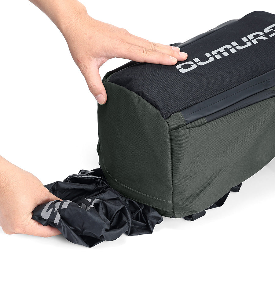 Rain cover being pulled from the bottom storage pocket of an OUMURS motorcycle backpack.