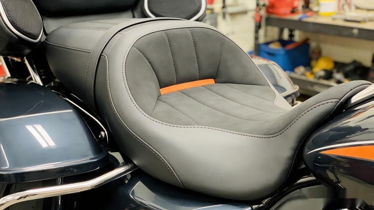 Black and grey leather motorcycle seat with orange accent for long distance riding comfort