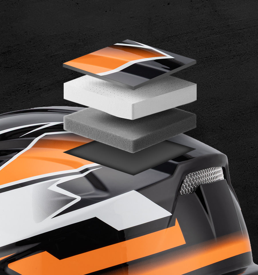 Close-up of a black, orange, and white helmet shell with layered foam and visor detail shown against a dark textured background.