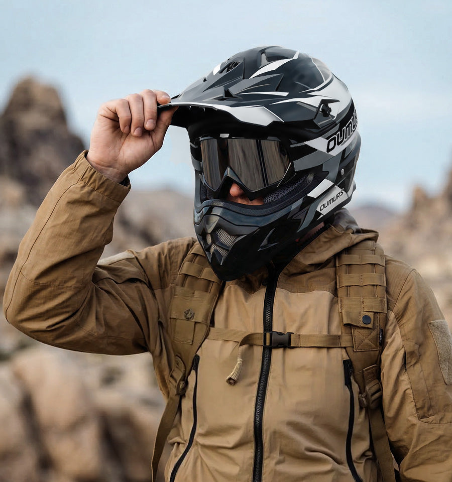 A rider wearing an Oumurs 805 victory gray off-road helmet with UV-protective goggles.
