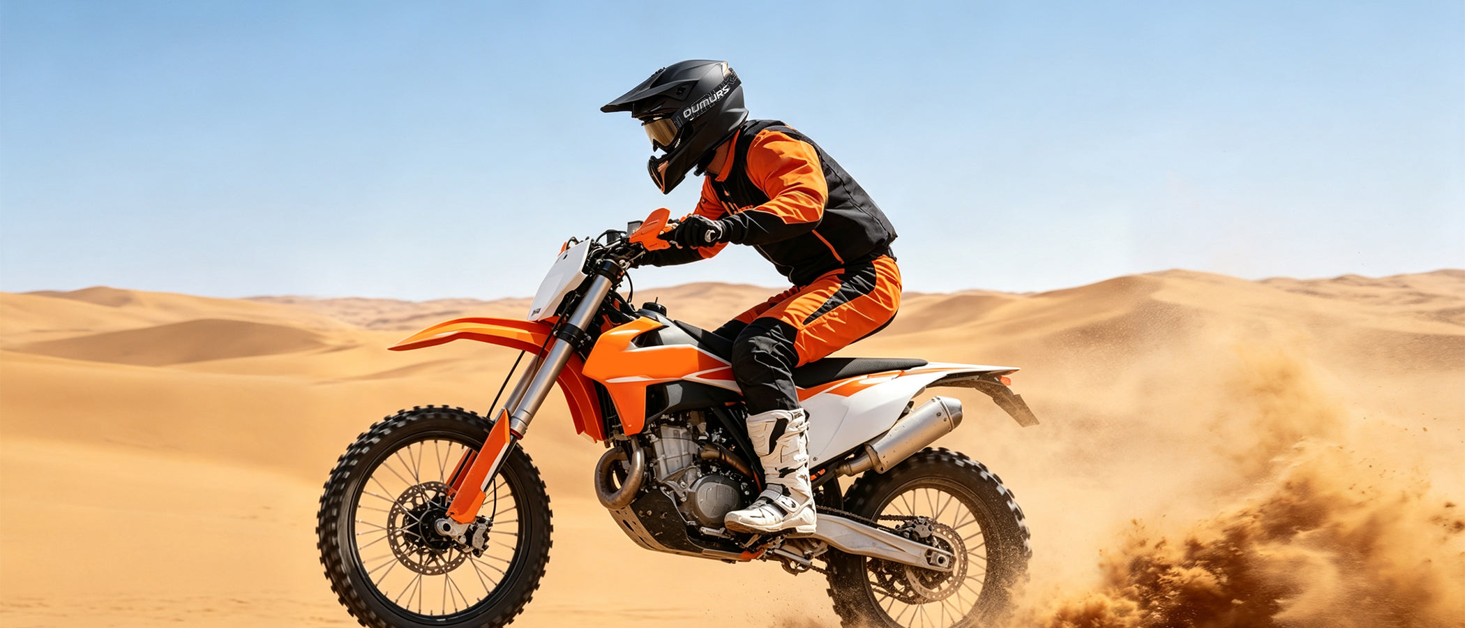 A rider wearing an Oumurs 806 Matte Black off-road helmet riding an orange and white dirt bike through a sandy desert and kicking up dust.