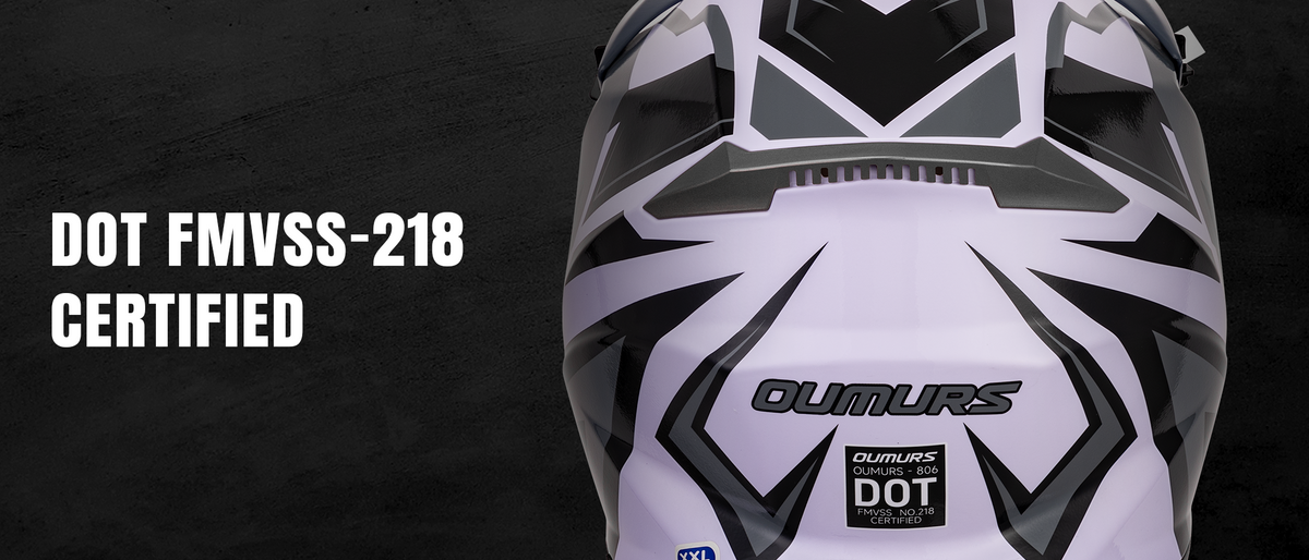 Close-up of a white, black, and gray Oumurs full-face motorcycle helmet on a dark textured background, with white text on the left reading 'DOT FMVSS-218 CERTIFIED'.