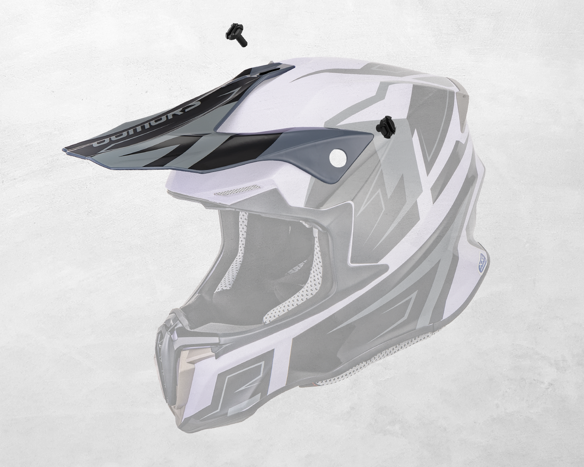 A white and gray full-face motocross helmet with a dark visor, shown on a light gray textured background. A small black accessory is floating above the visor, and the brand name 'MotoGrip' is visible on the visor.