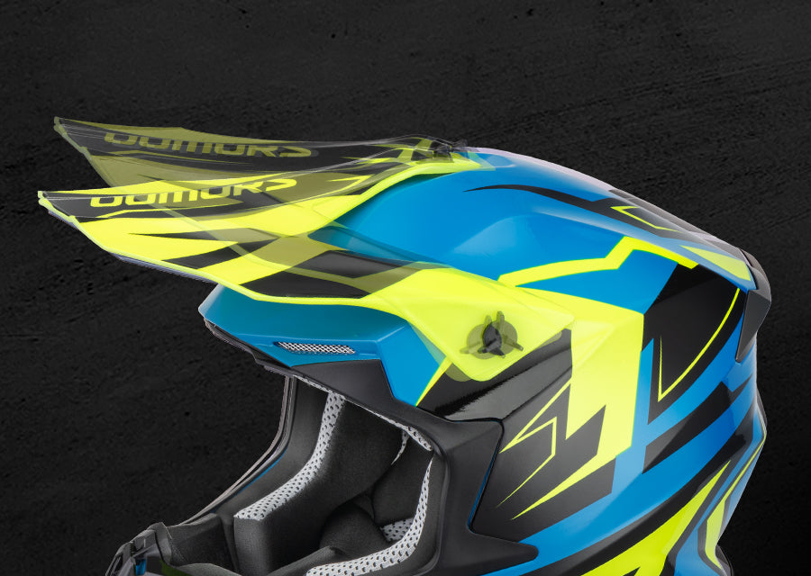 A close-up of a motocross helmet featuring a vibrant blue and neon yellow color scheme with black accents, set against a dark textured background.