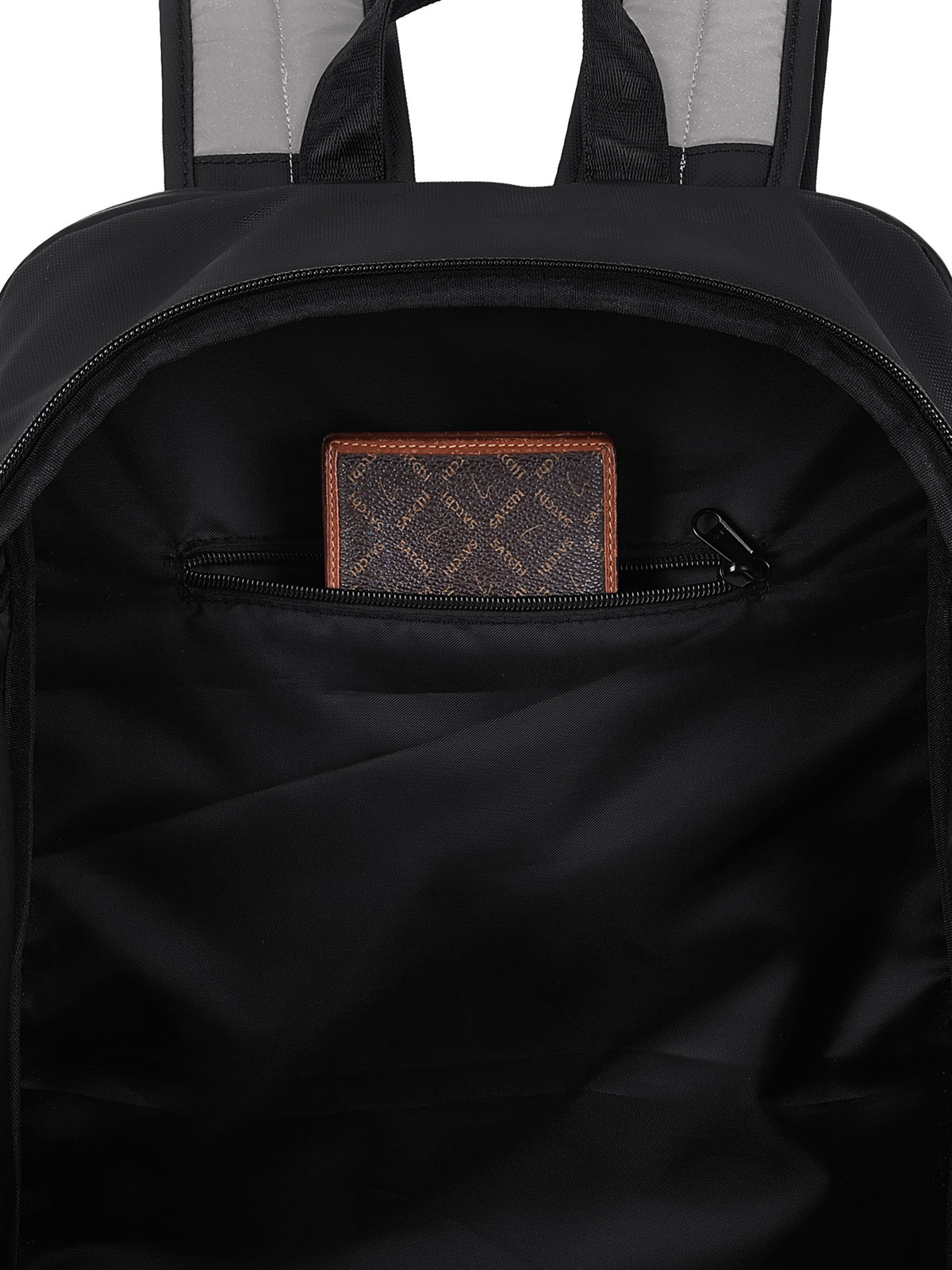 Close-up of the inside of a black backpack showing a zippered pocket with a brown patterned card or wallet resting inside.