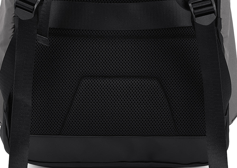 Close-up of the back of a black backpack showing a large black mesh ventilation panel, padded shoulder straps, and a black bottom base.