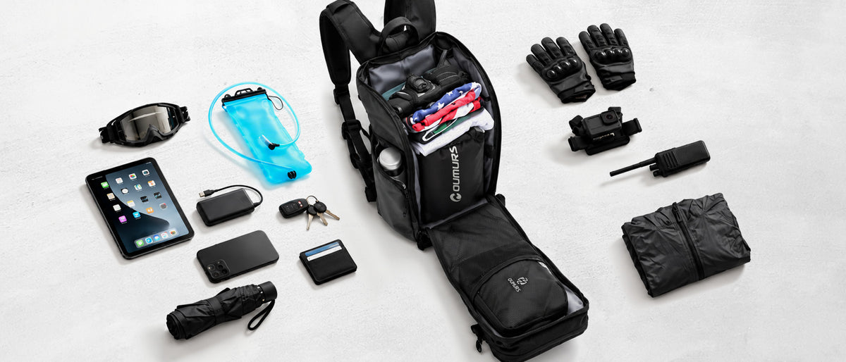 Open Oumurs 15L motorcycle backpack surrounded by riding gear, a hydration bladder, electronics and everyday essentials.