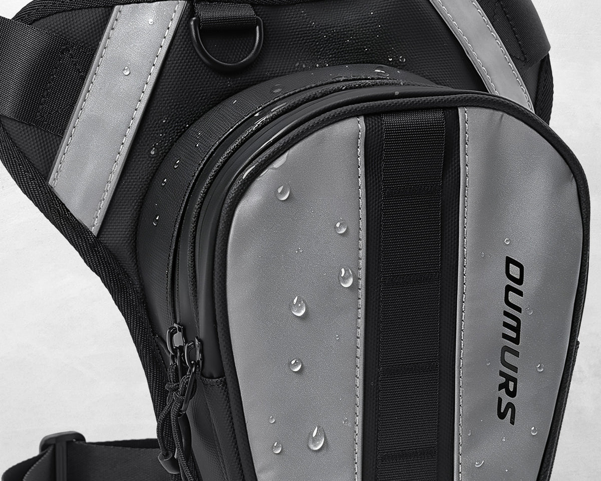 Water droplets on the black and gray front panel of an Oumurs motorcycle leg bag.