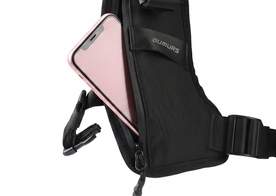 Close-up of an OUMURS motorcycle backpack chest strap pocket holding a smartphone.